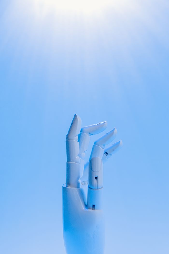 Home A robotic hand reaching upward against a blue sky, symbolizing technology's future.